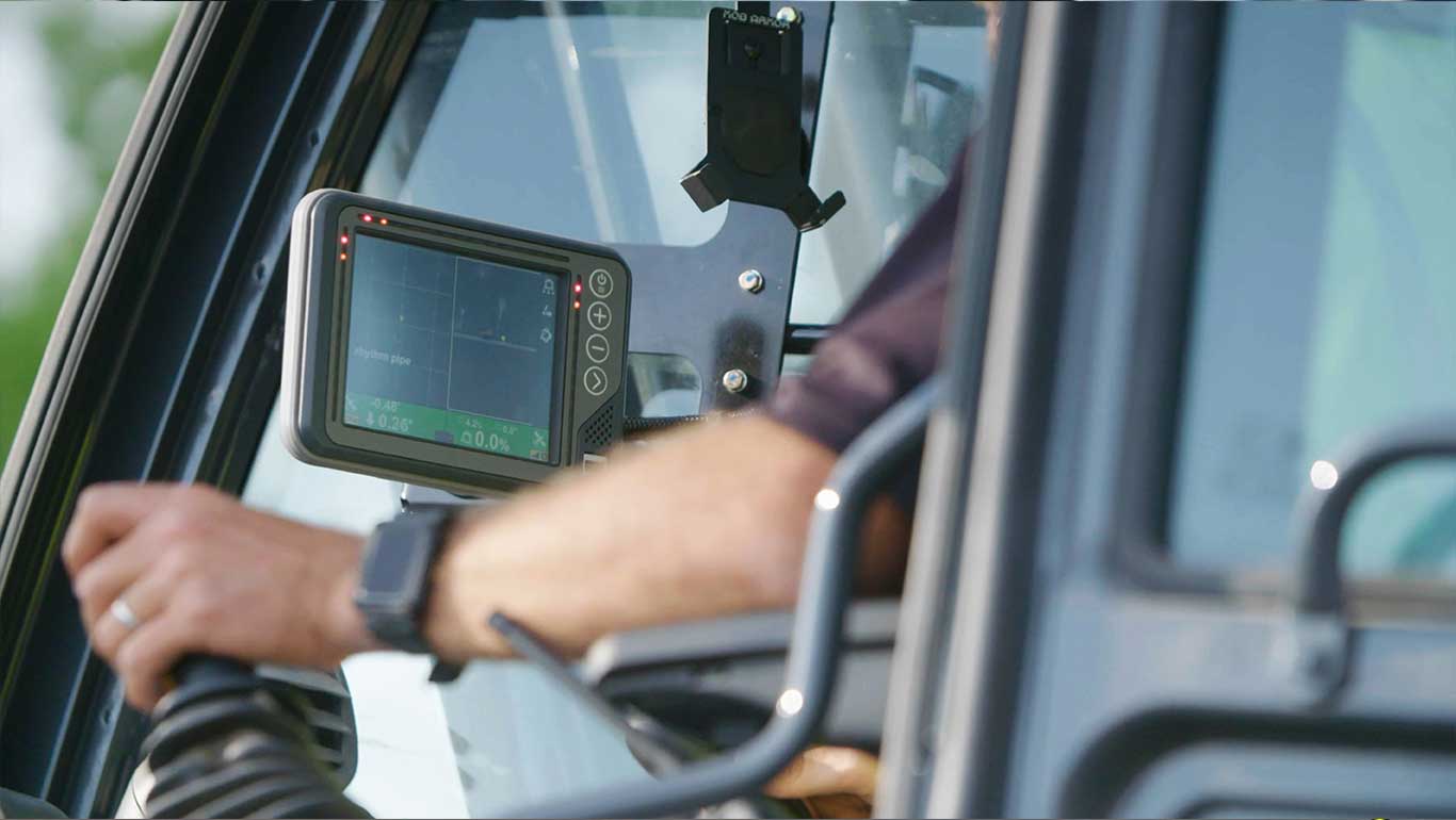 hand of the machine operator utilizing the display and joystick in a piece of John Deere equipment.
