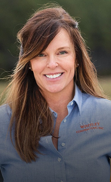 Brandy Whitley, debout sur un chantier, regarde vers la caméra.