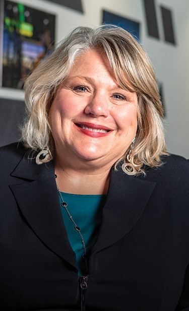 Diane Benck is seated at the conference table at the West Side Tractor Sales headquarters.