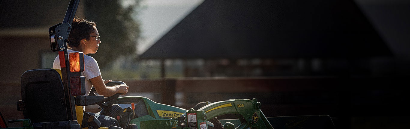 person operating tractor with 120R Loader attached