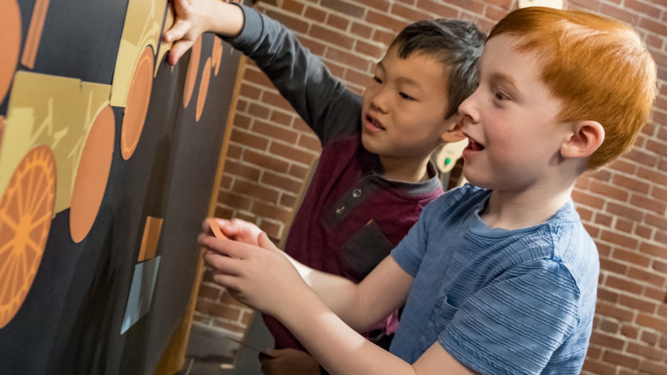 Deux gar&ccedil;ons jouant dans une partie de l&rsquo;exposition de tracteur