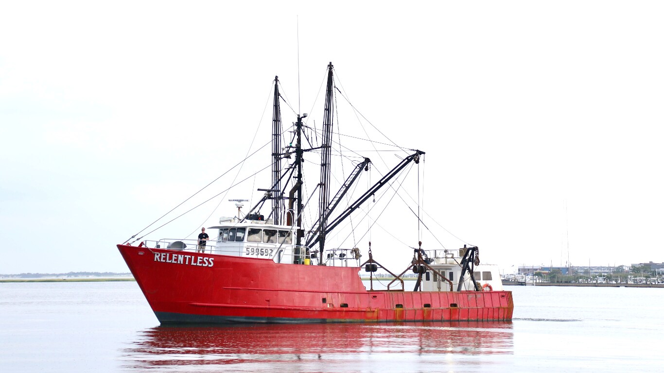 Bright red commercial fishing boat “Relentless” sitting in the water.