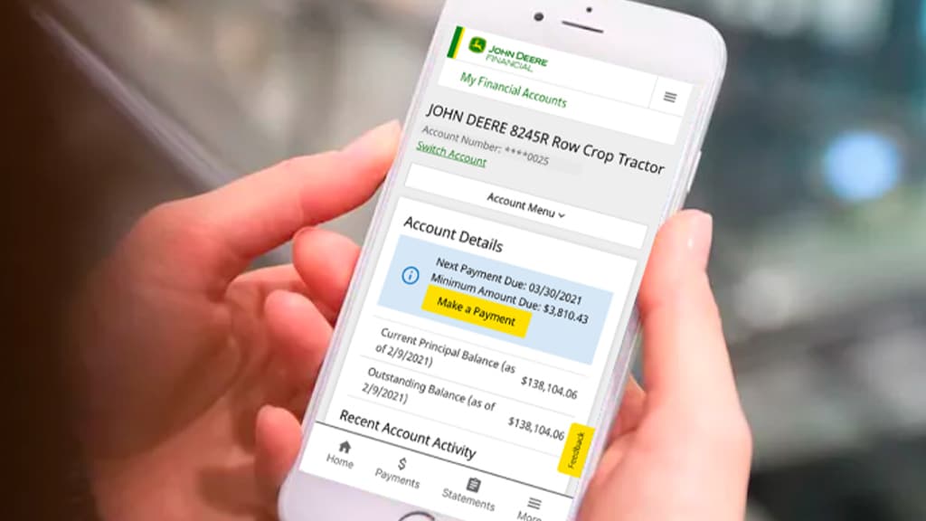 Mains qui tiennent un téléphone dont l’écran affiche l’application John&nbsp;Deere Financial