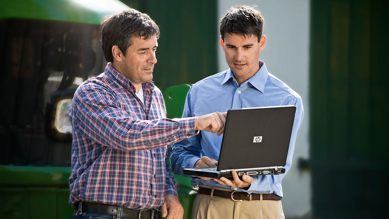 Deux hommes en conversation regardant un portable