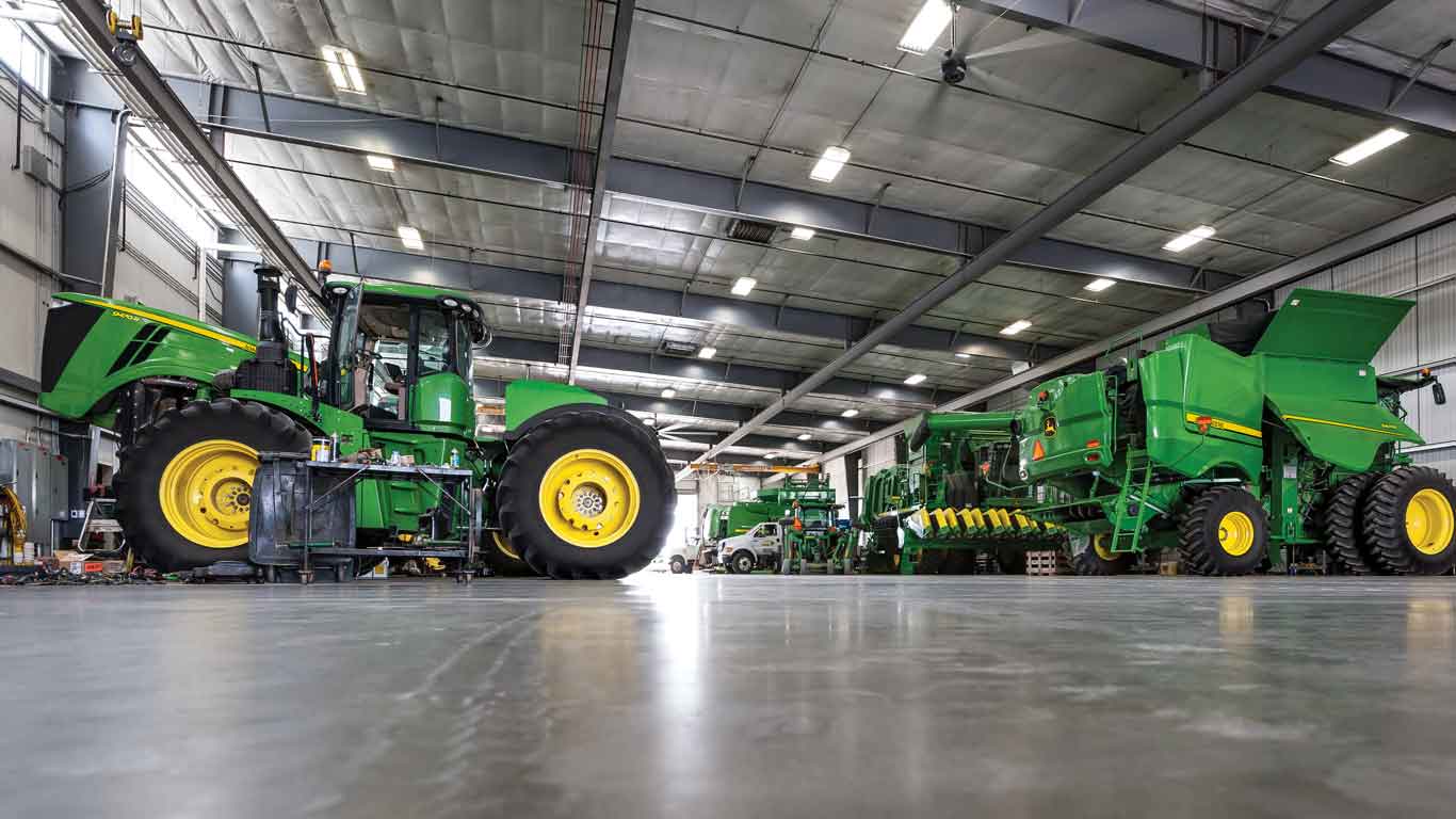 Un tracteur et une moissonneuse-batteuse John Deere dans un entrepôt