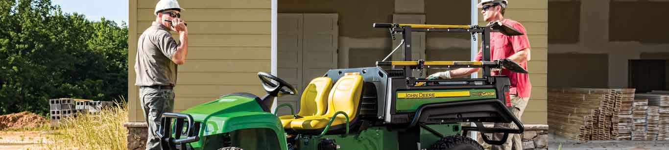 Two landscapers on a site with a John Deere Gator UTV