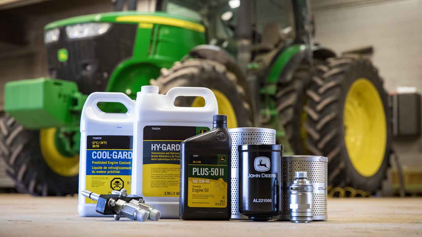 John Deere parts and oil sitting on shop floor