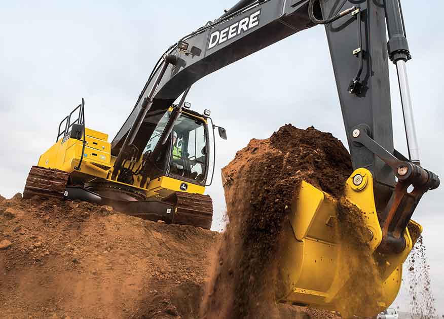 Équipement de construction John Deere creusant un trou dans le sol