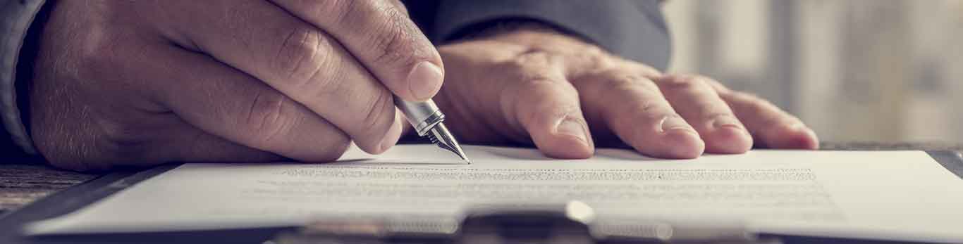 Image of someone signing a document