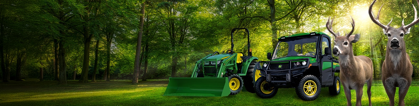 Bucks in front of gator and lawn tractor in a forest with Deere Season written