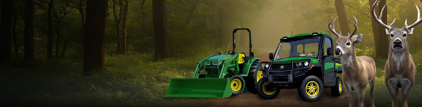Bucks in front of gator and lawn tractor in a forest with Deere Season written
