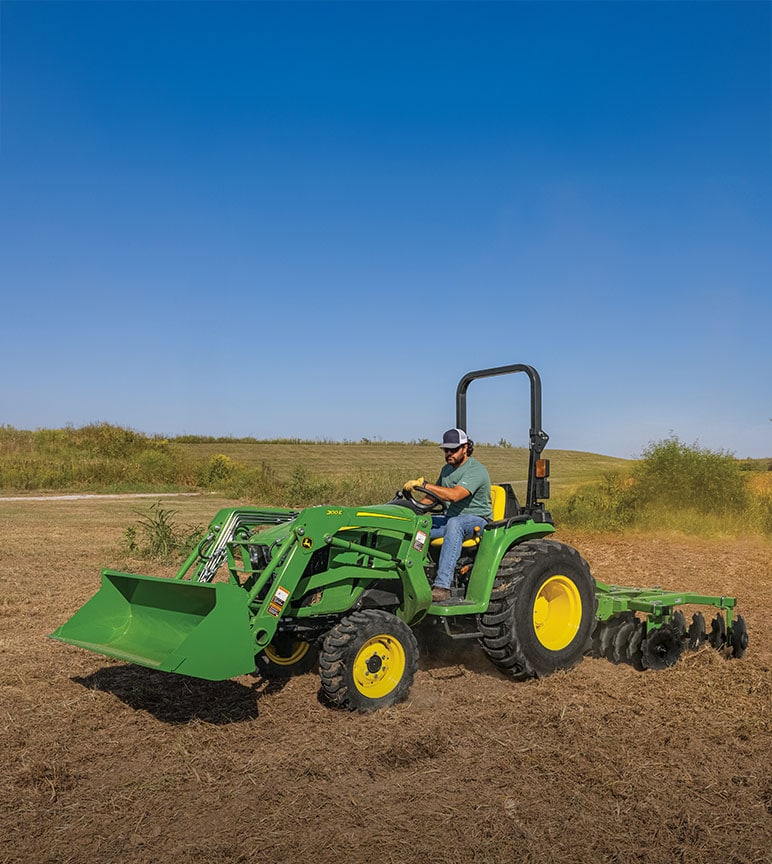 A man using a John Deere 3E Series Tractor and Frontier™ tandem disk harrow to till land.