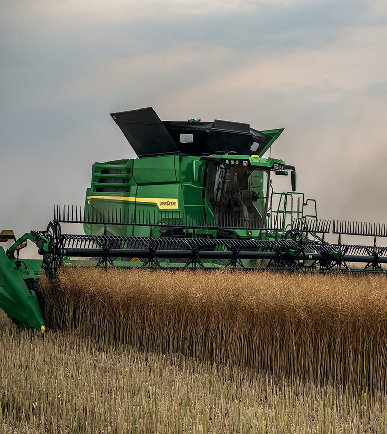 John Deere combine in a wheat field.