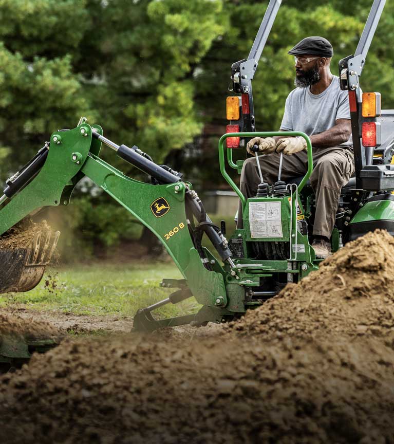 tractor with loader digging up dirt