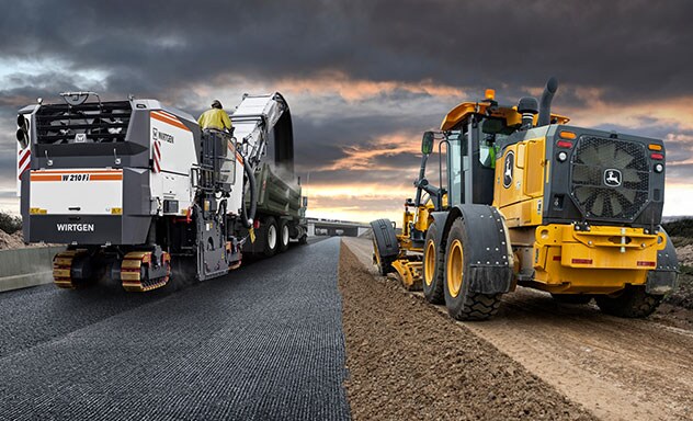 Machines de construction des chaussées de Wirtgen et de John Deere au travail côte à côte
