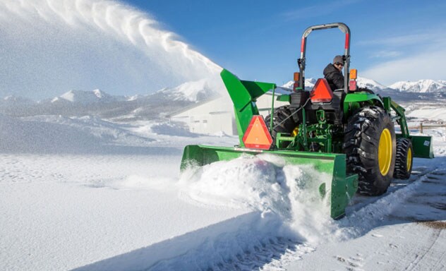 Tractor with Frontier SB1174 3-Point Snowblower attachment blowing large volumes of snow.