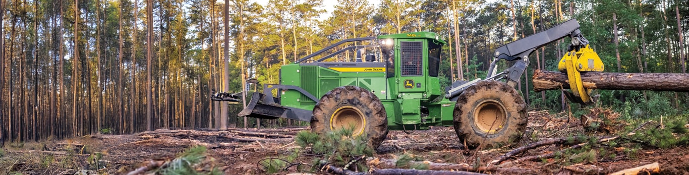 L-III Skidder in the woods holding up a tree log.