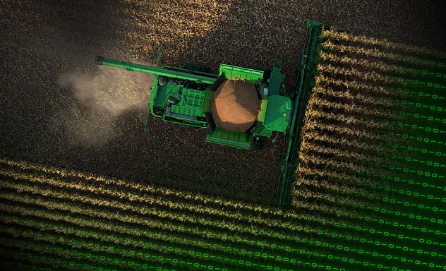 Arial view of combine harvesting in a corn field.