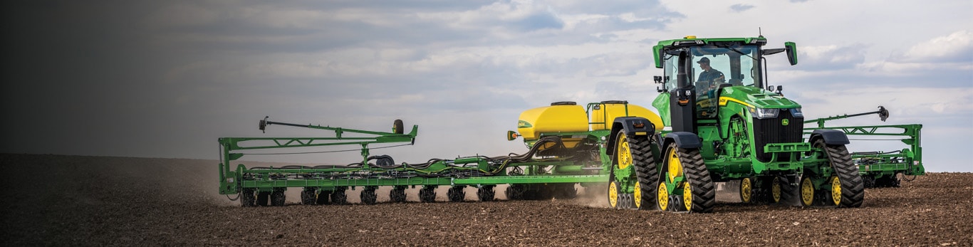 John Deere 9rx pulling Planter in a fallow field.