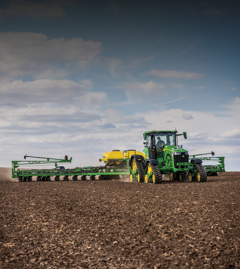 John Deere 9rx pulling Planter in a fallow field.