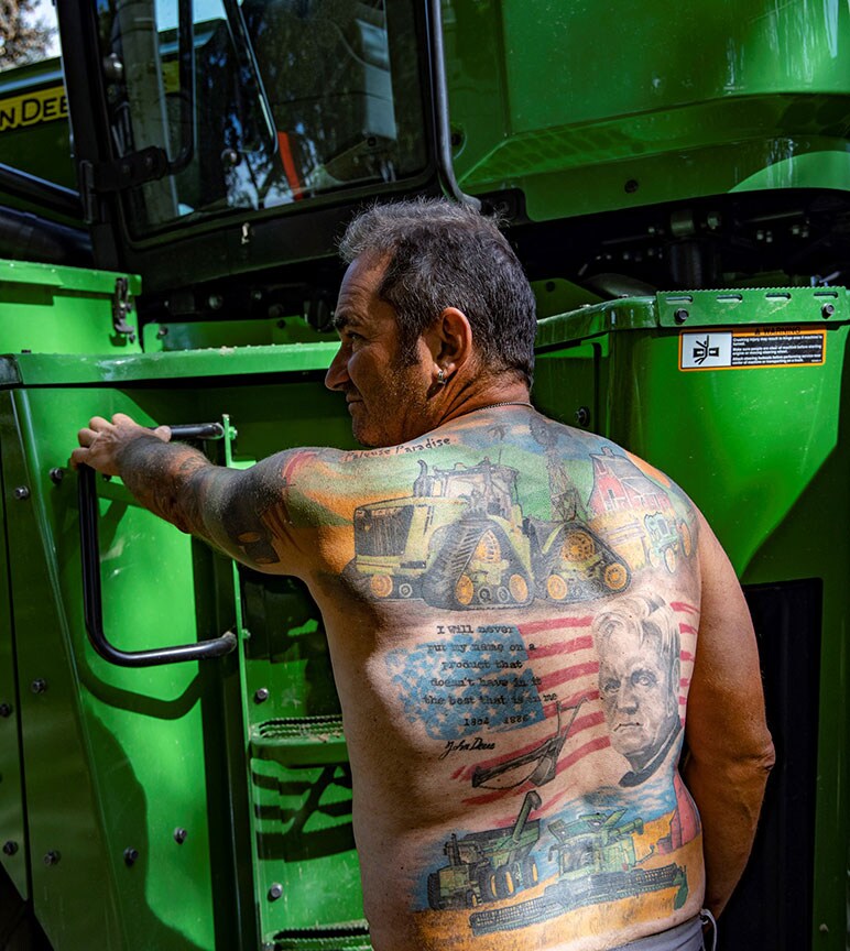 Jean-Charles Reihle, torse nu, montrant les nombreux tatouages ayant pour thème John Deere, qui ornent son dos et son bras