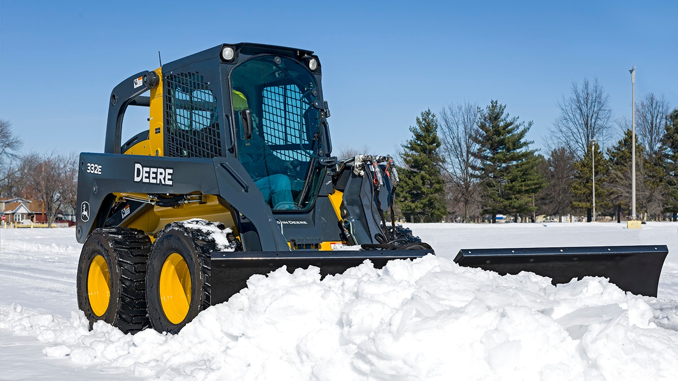 332E Skid Steer with Snow V-Blade attachment in snow