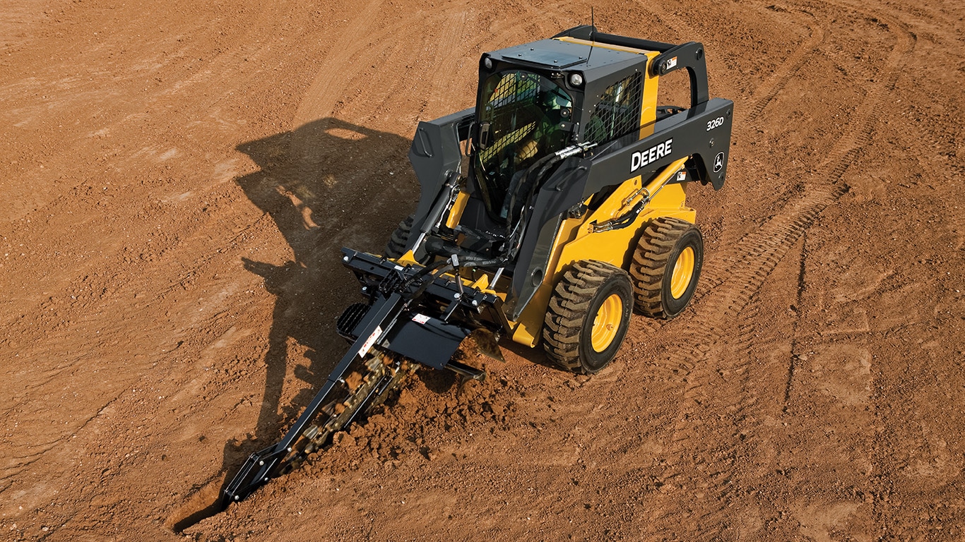 326D Skid Steer with trencher attachment working in the middle of a jobsite.