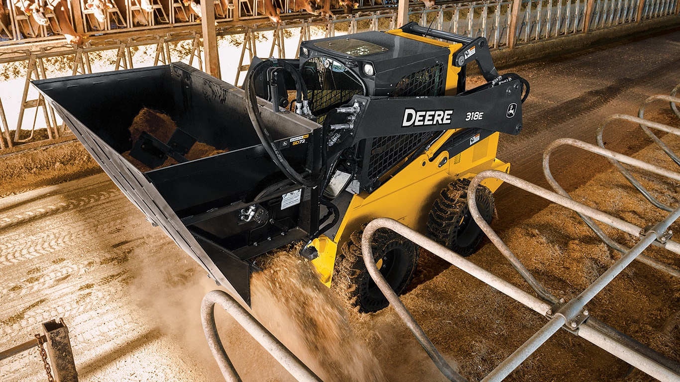 Chargeuse à direction différentielle John Deere avec accessoire de benne à déversement