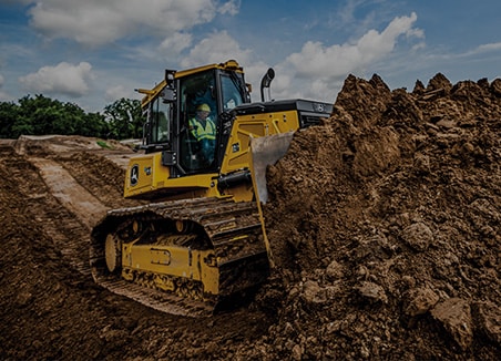 The words “site development” are on top of a John Deere 750L SmartGrade Dozer pushing dirt to prepare the site. 