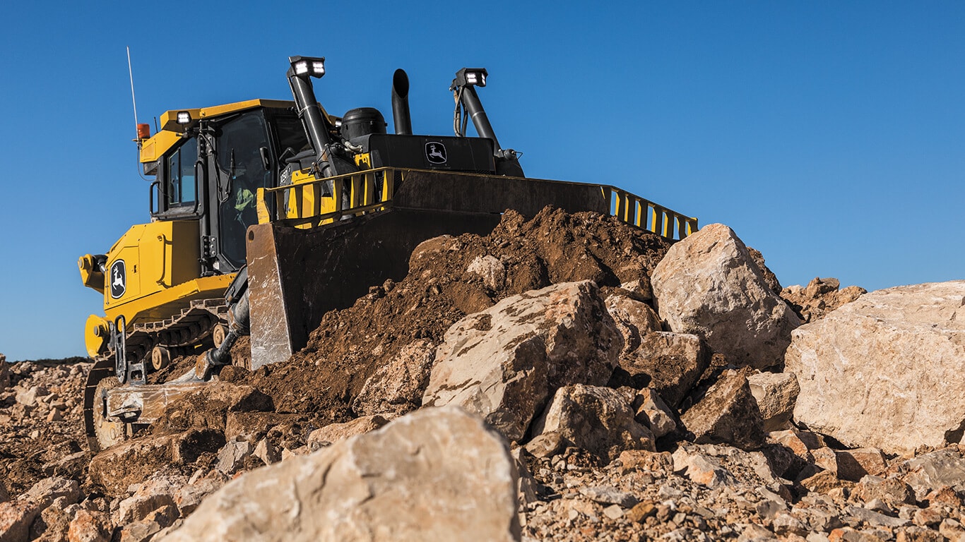 Bouteur John Deere déplaçant des gravats et de la terre sur le chantier.