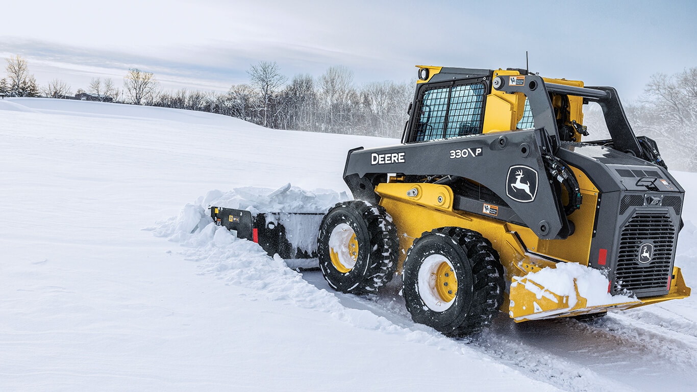 330 P-Tier skid steer using snow pusher attachment.
