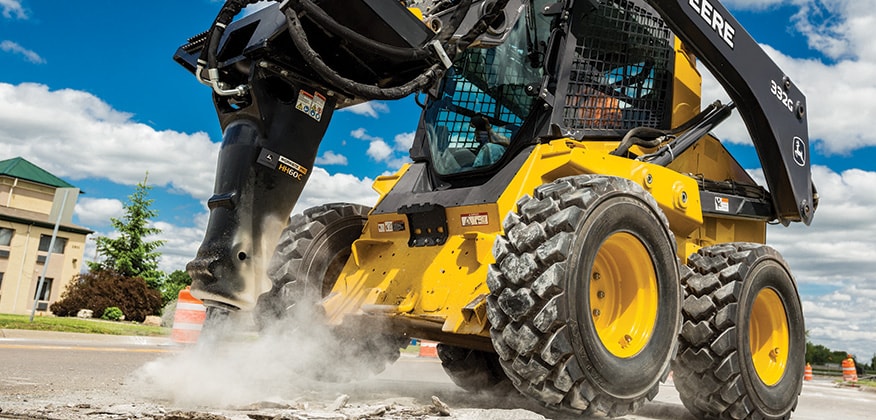 332G Skid Steer with Hydraulic Hammer attachment breaking up a street