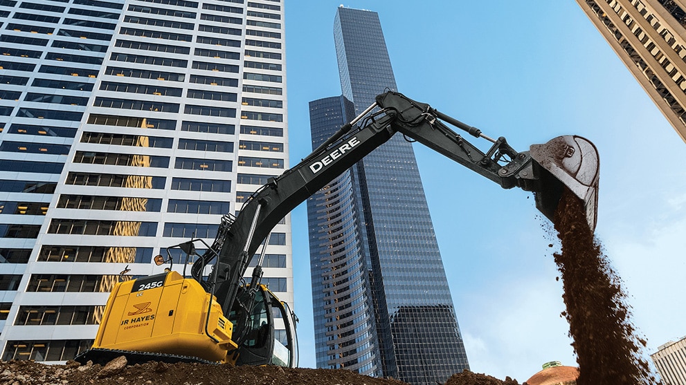 Excavatrice travaillant avec un paysage urbain en arrière-plan