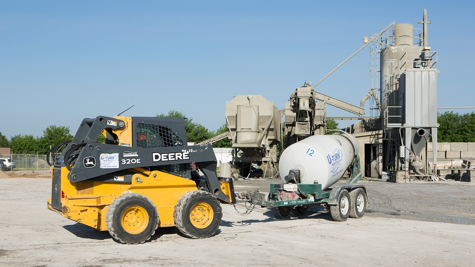 320E skid steer pulls a concrete mixer