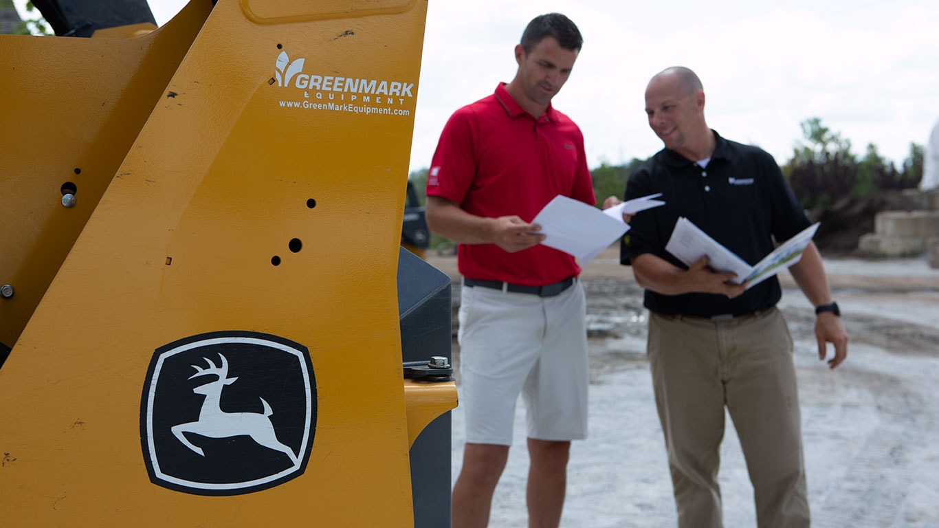 Two men reviewing plans on a worksite