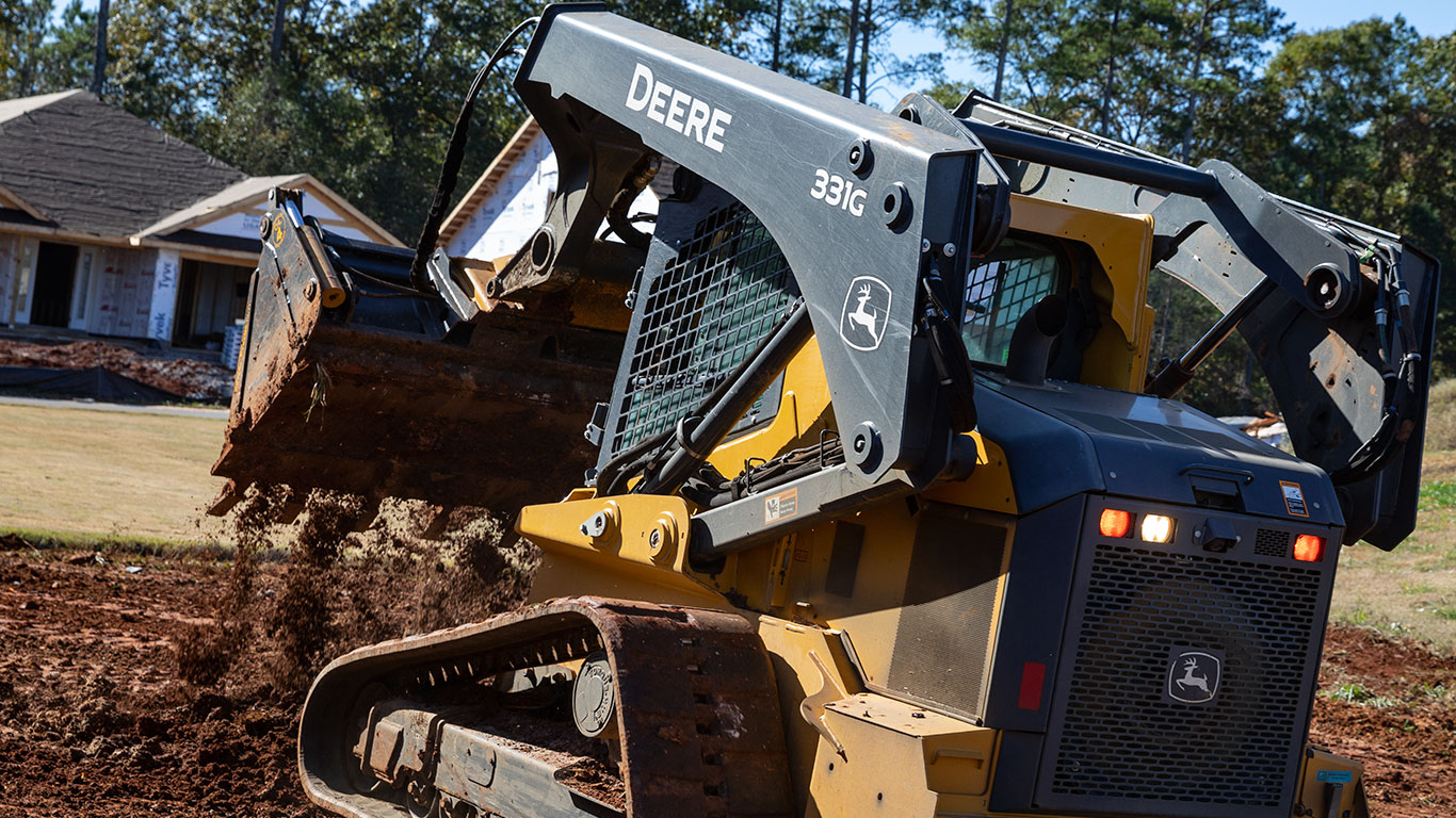 A 331G dumping a load of dirt on a residential job site