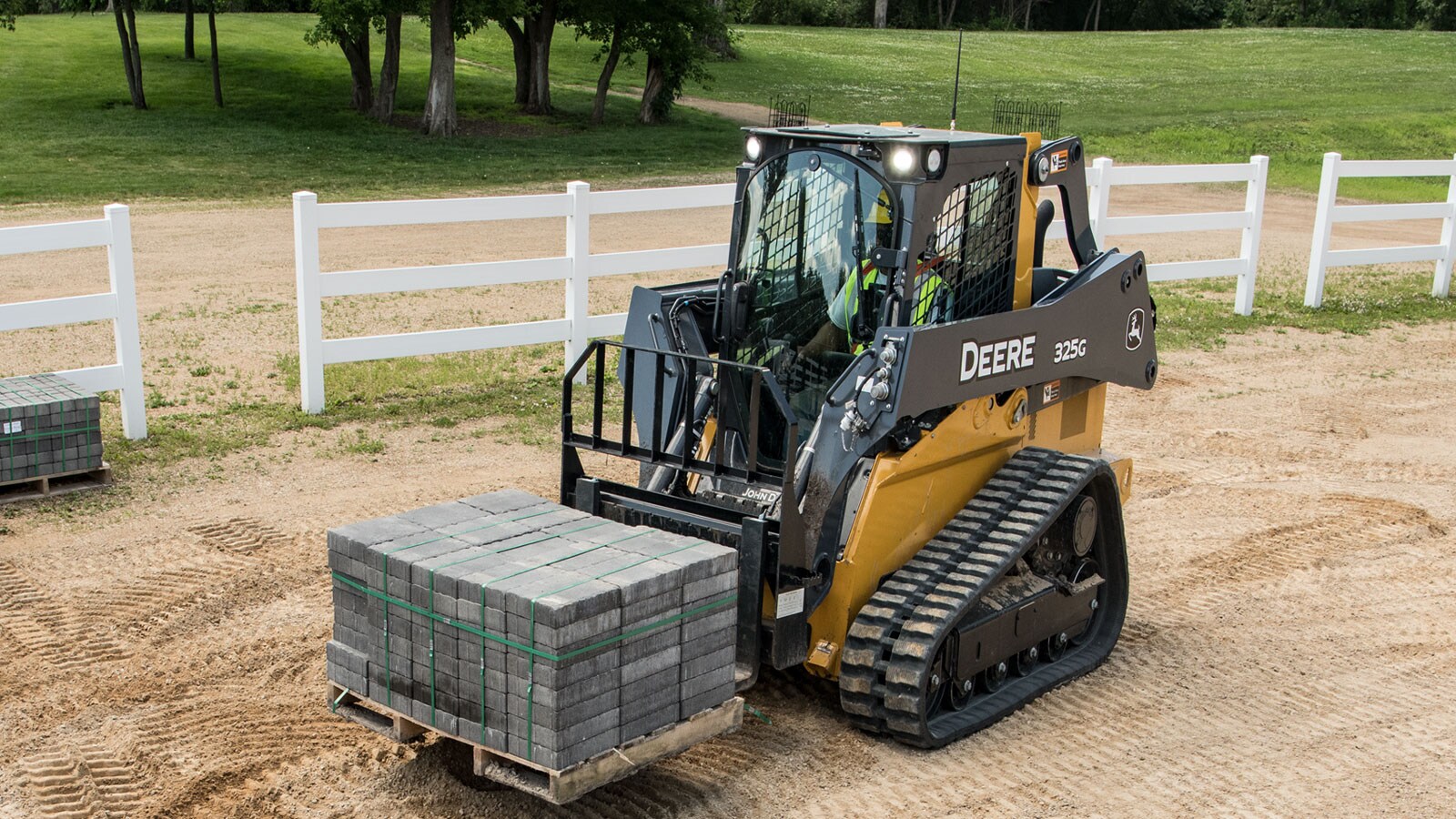 A 325G carrying a pallet of bricks.