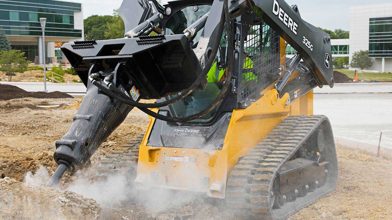 John Deere 325G Compact Track Loader breaking cement with Worksite Pro Attachment