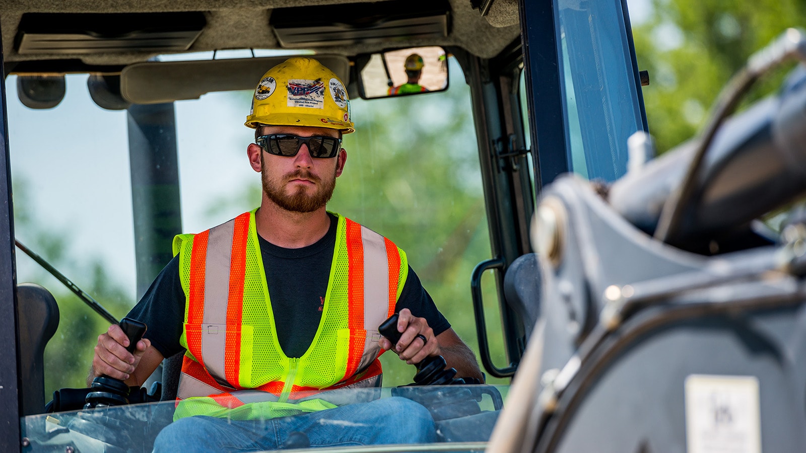 Close up of an operator working in an excavator cab