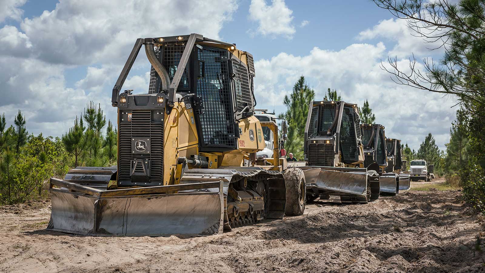 Line of John Deere dozers heading to the swamp