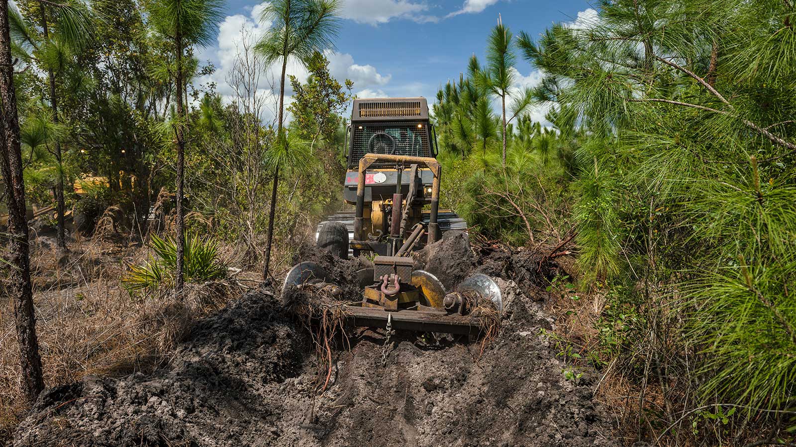 A John Deere dozer digs into the sandy soil