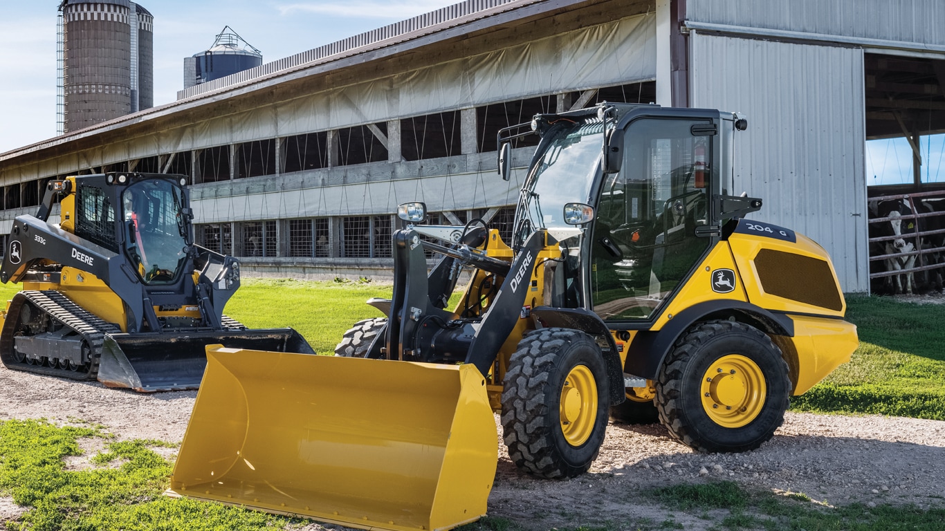 Skid steer on a farm moving a hay bale