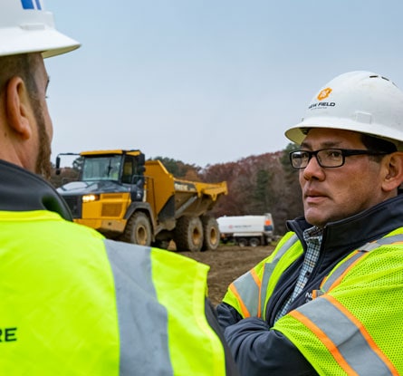 Two men on a construction site having a discussion.