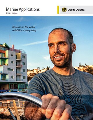 Man drives boat with buildings and mountains in the background.