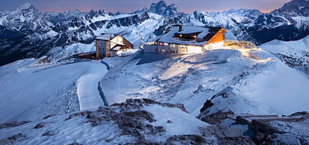 Cabines sur un pic montagneux avec des lumières éclatantes.