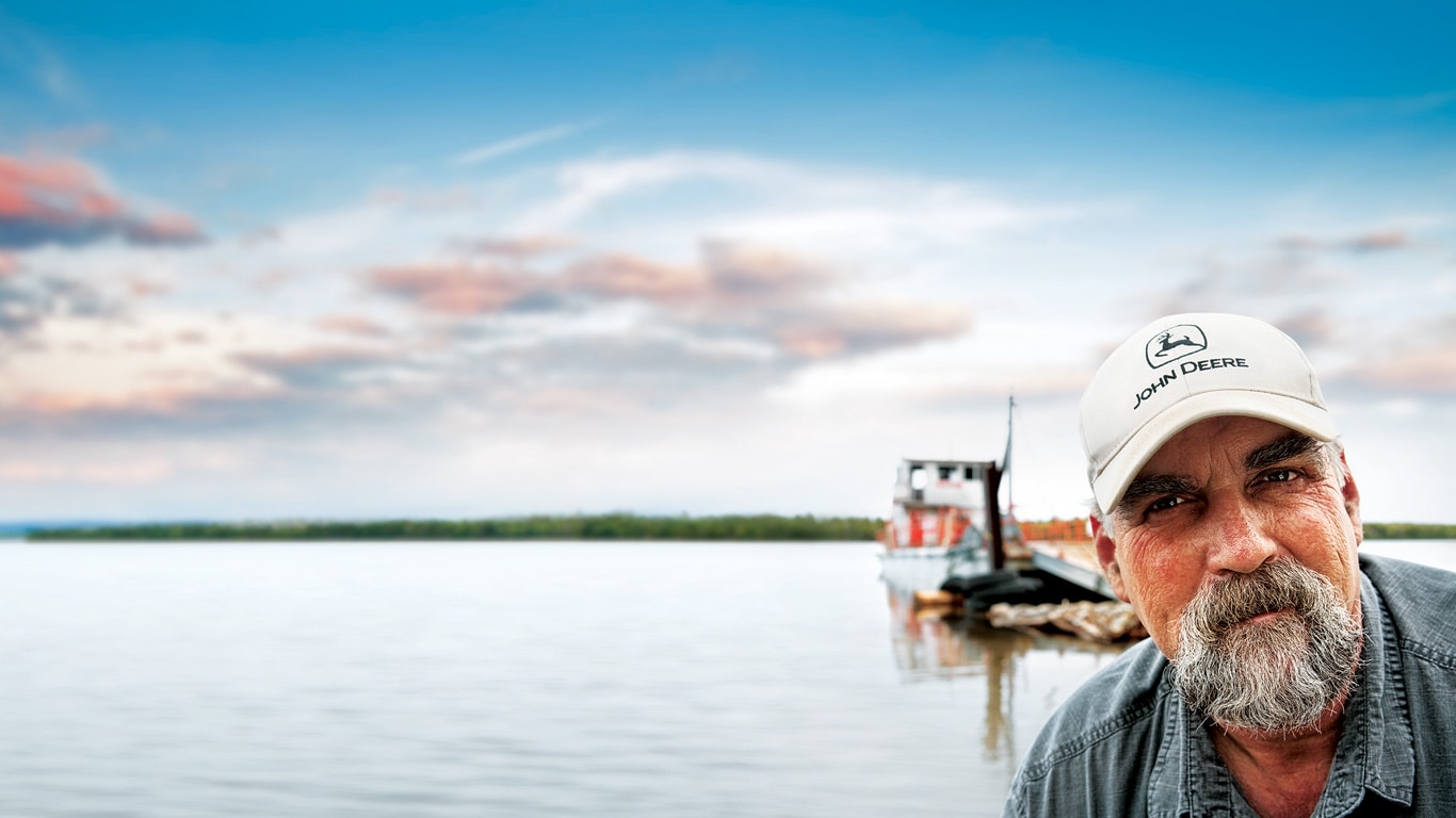 Un client et un pêcheur sur un quai regardent en direction de la caméra