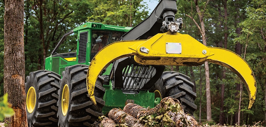 648L-II Skidder opens its grapple wide to pick up a load of logs