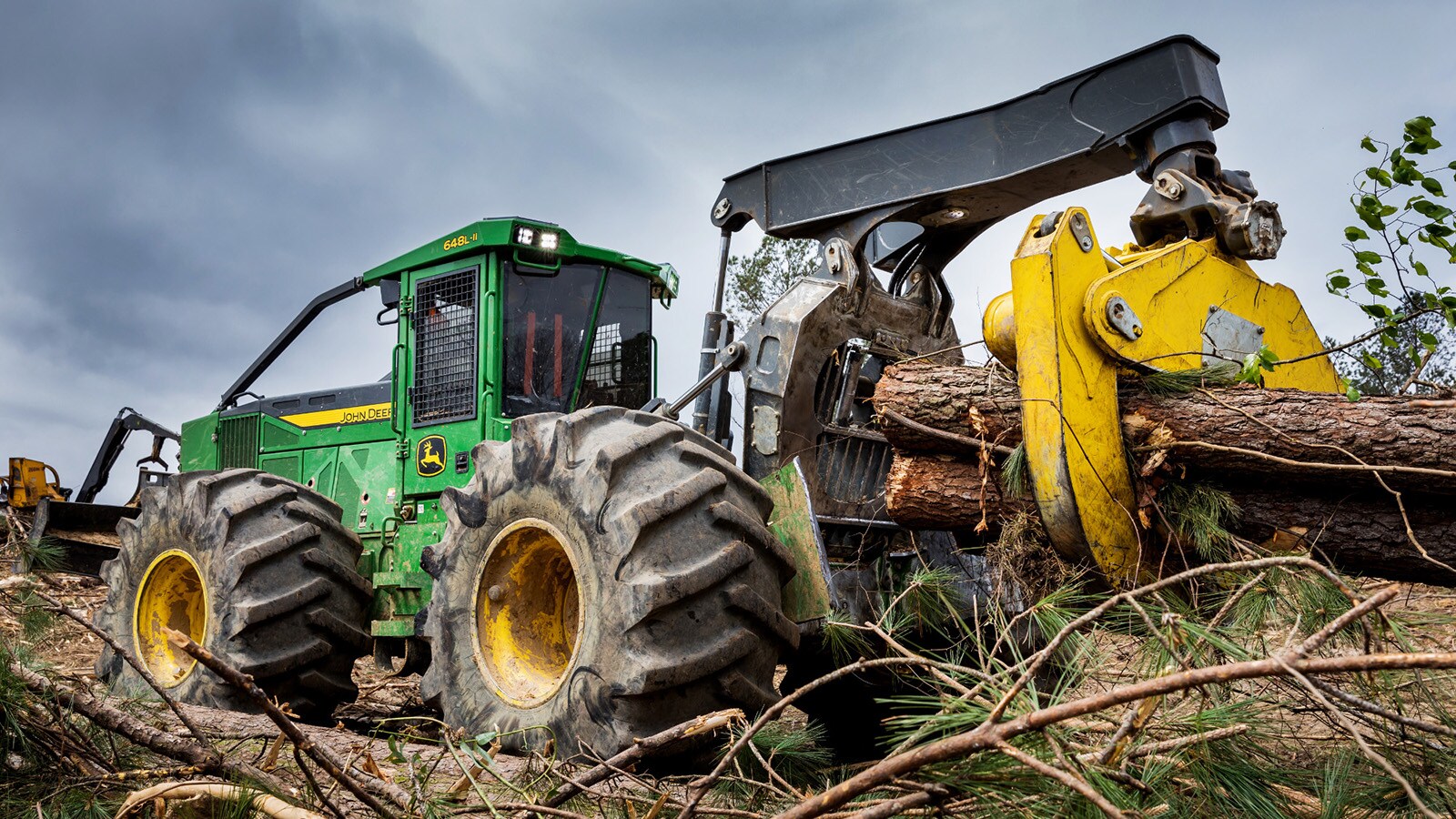 648L-II Skidder hauls logs through a pile of brush