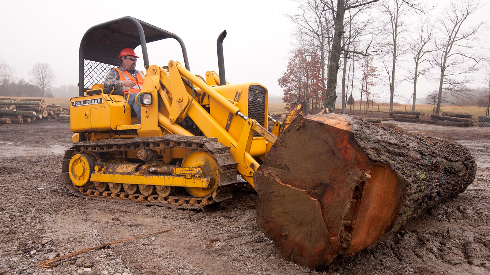Danny Richards uses a John Deere crawler to move a large log