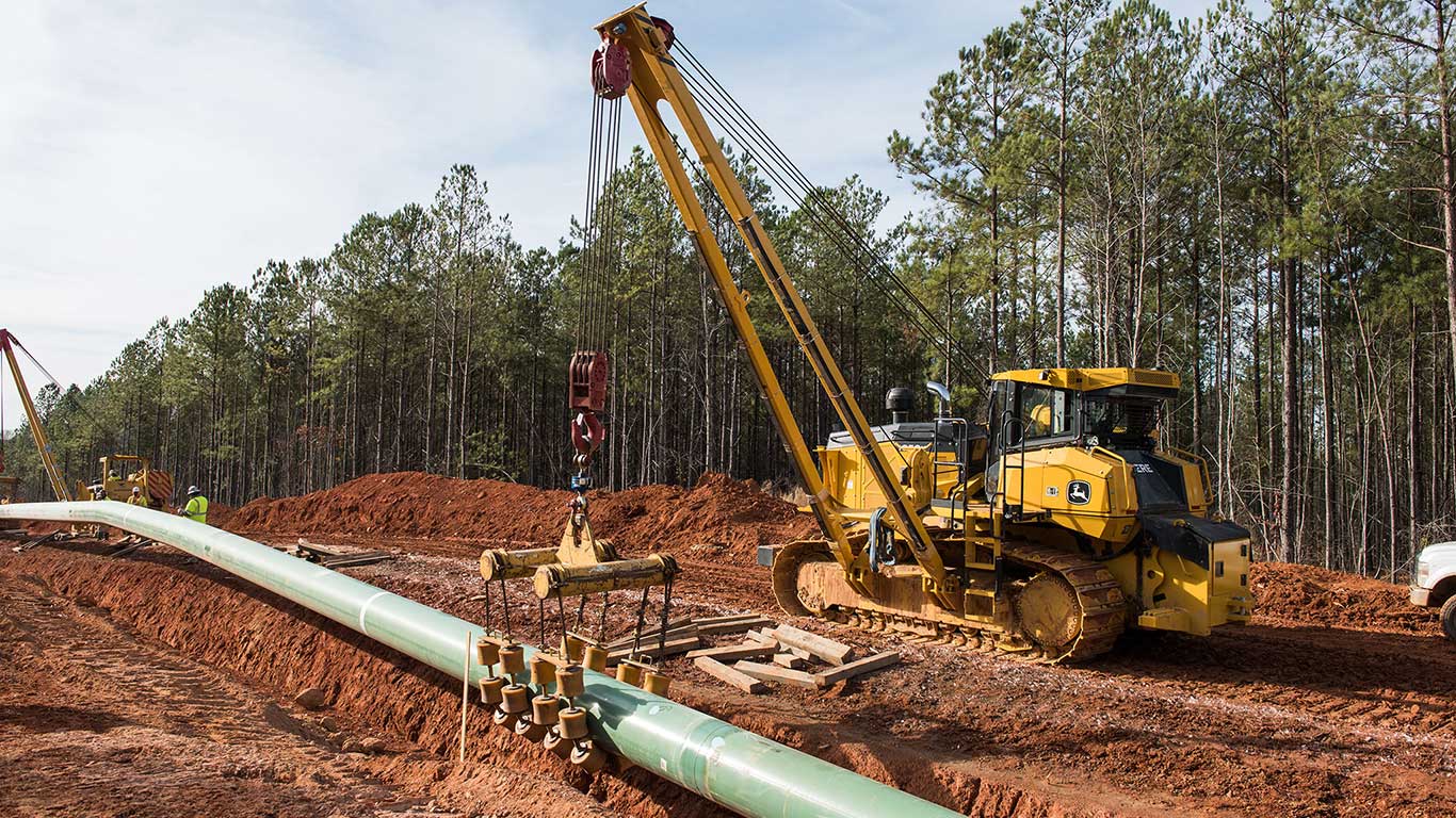 1050K Pipeline-Ready Dozer with side boom and winch moving a pipe
